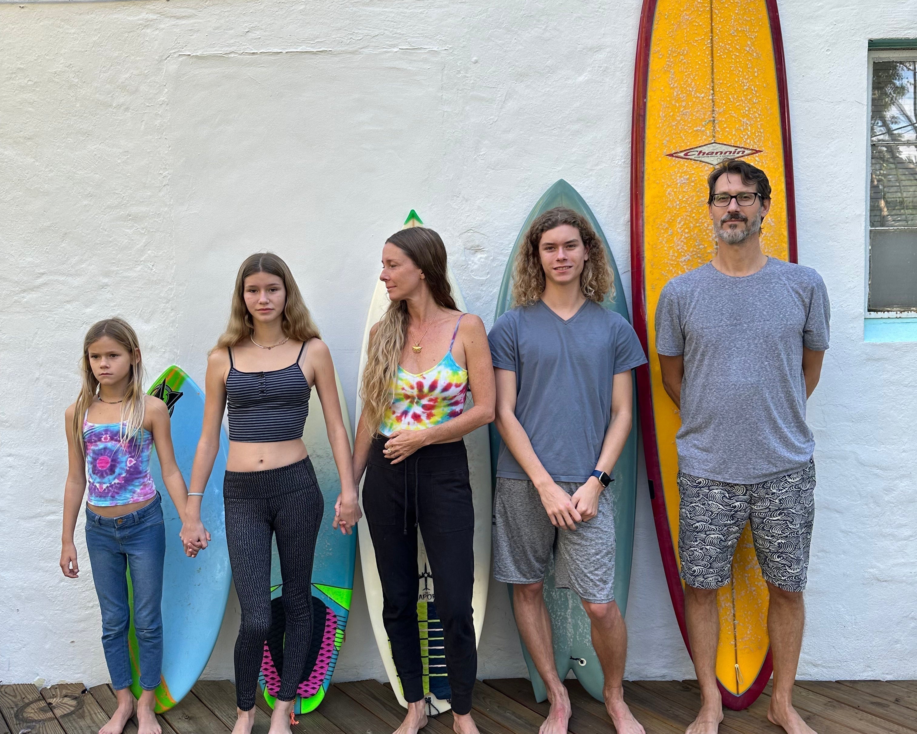 family in front of surf boards