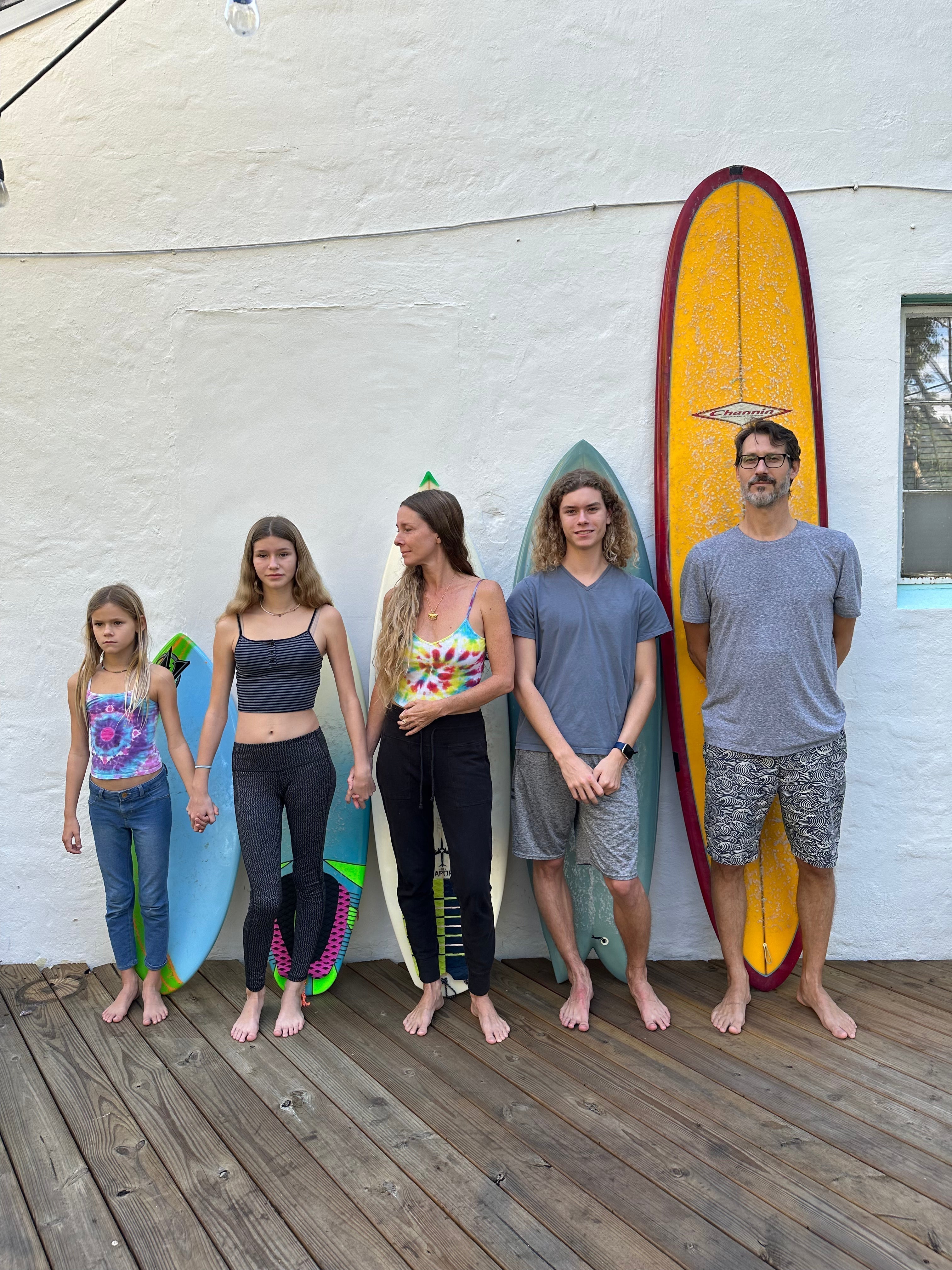 family in front of surf boards